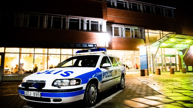 Polisbil framför en byggnad.