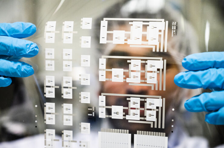 Forskare håller fram en folie med tusentals tryckta transistorer.