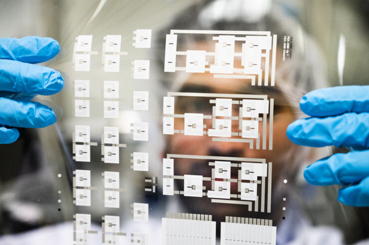 A researcher holds a plastic foil with thousands of printed transistors.