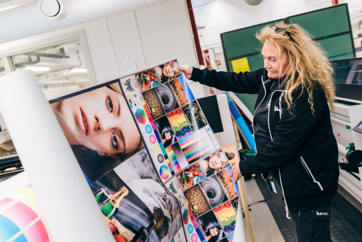 Woman showing a print example from the large-format printer.