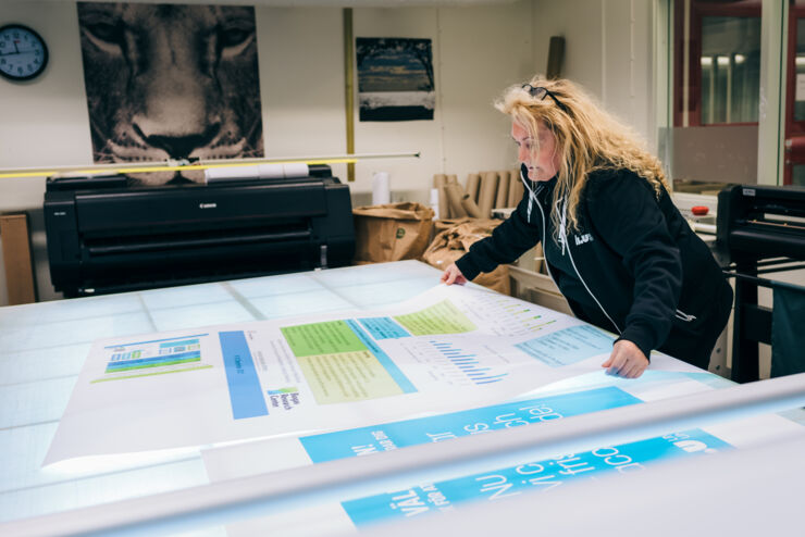 A woman with one of the many scientific posters that LiU Tryck has produced.