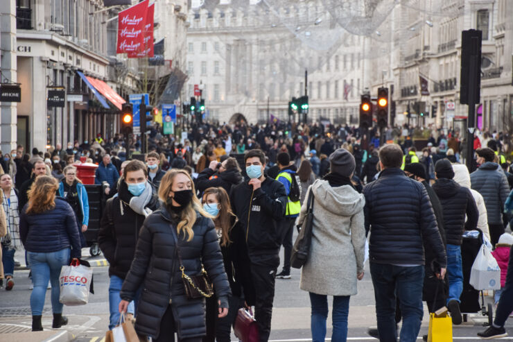 Folkmassa med munskydd på gågata i Storbritannien.