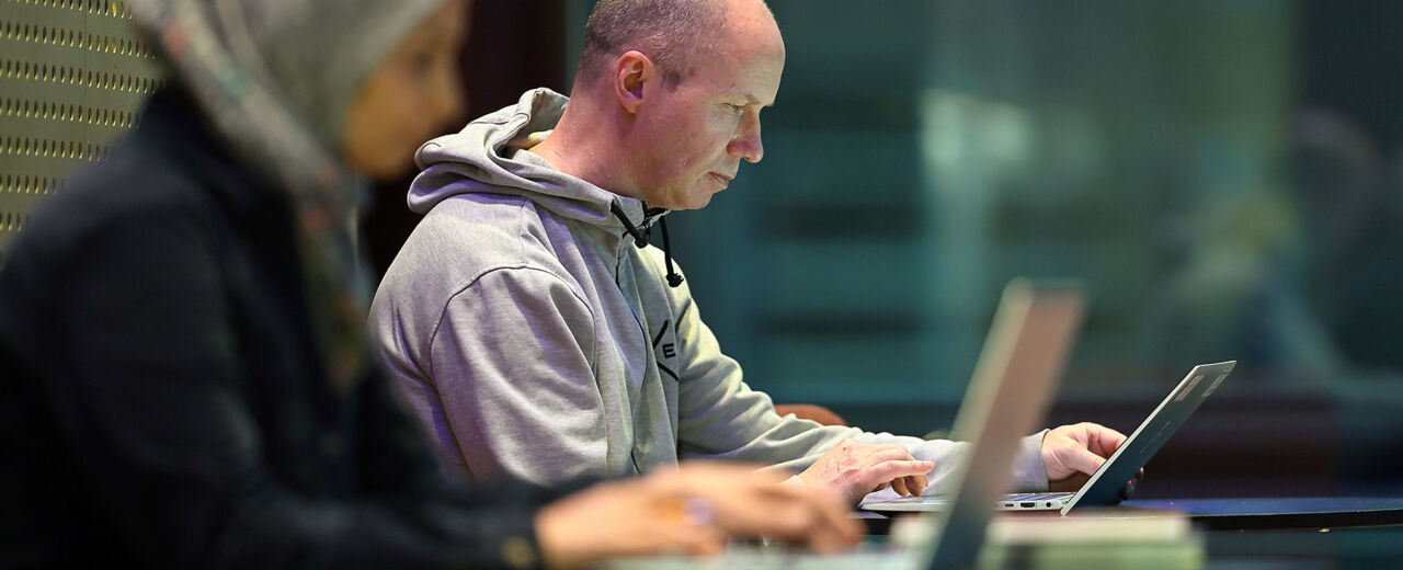 A man and a woman sit at their own little table and study.