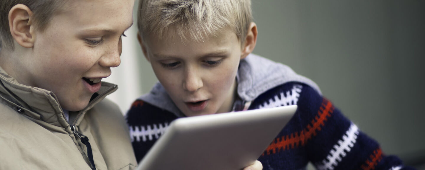 Boys looking at an ipad. 