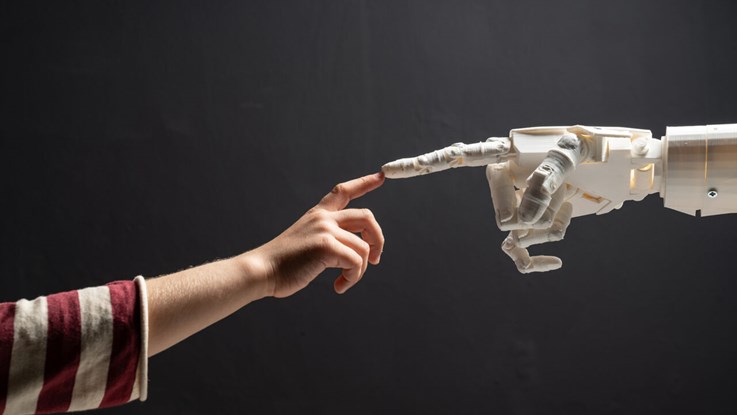 A child finger is touching a robot finger