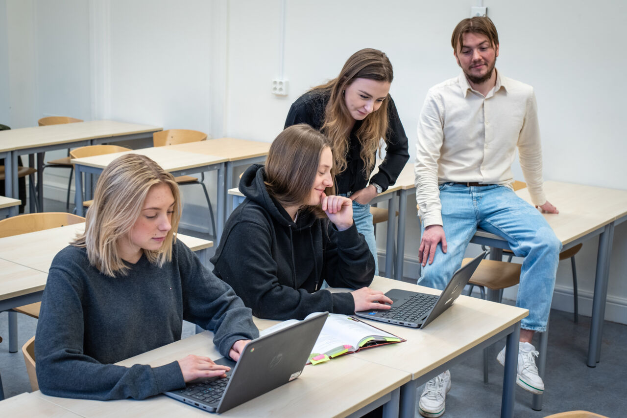 Två lärarstudenter hjälper två elever.