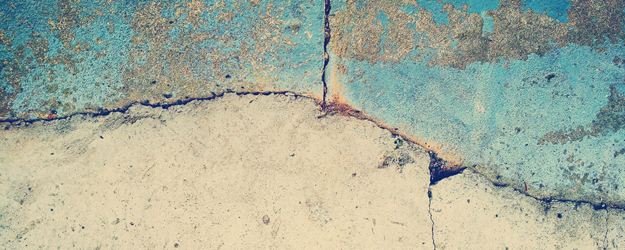 A picture of a wall with clear cracks.