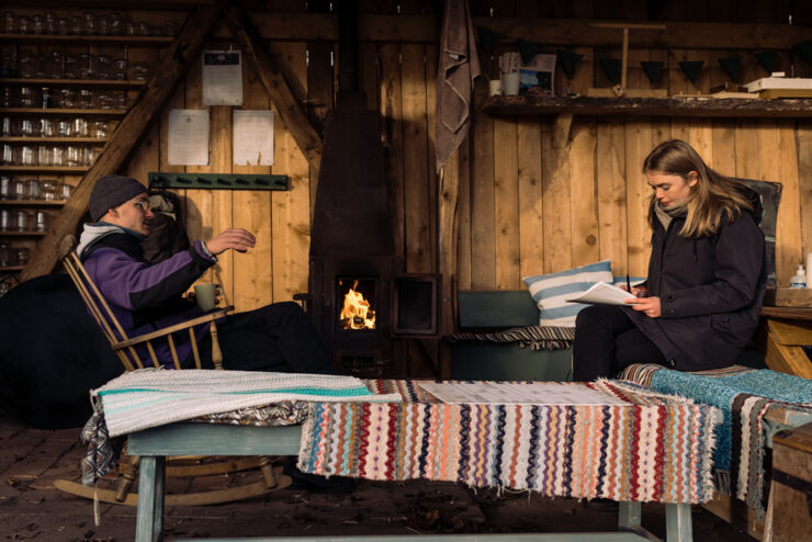 Two persons talking in a garden shed.