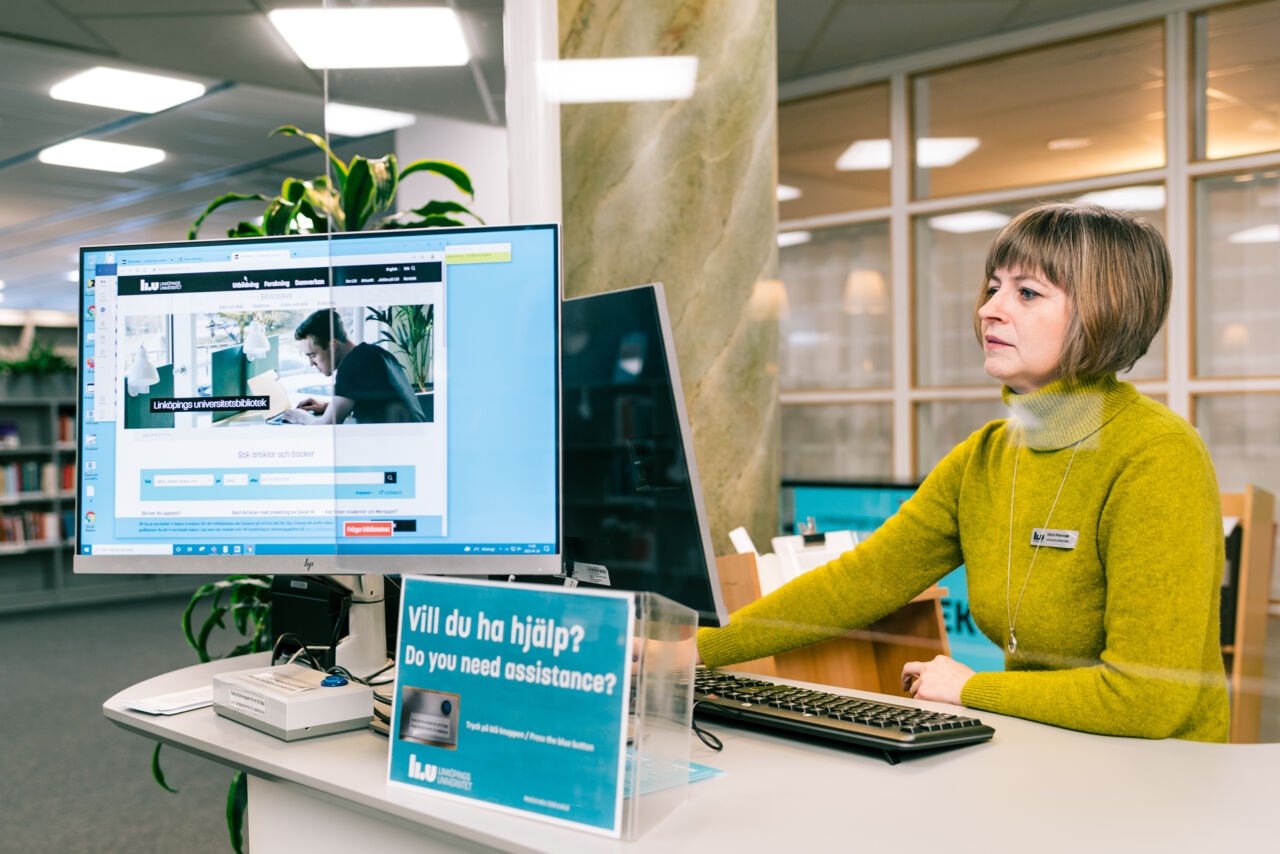 A librarian at an enquiry desk at a library.