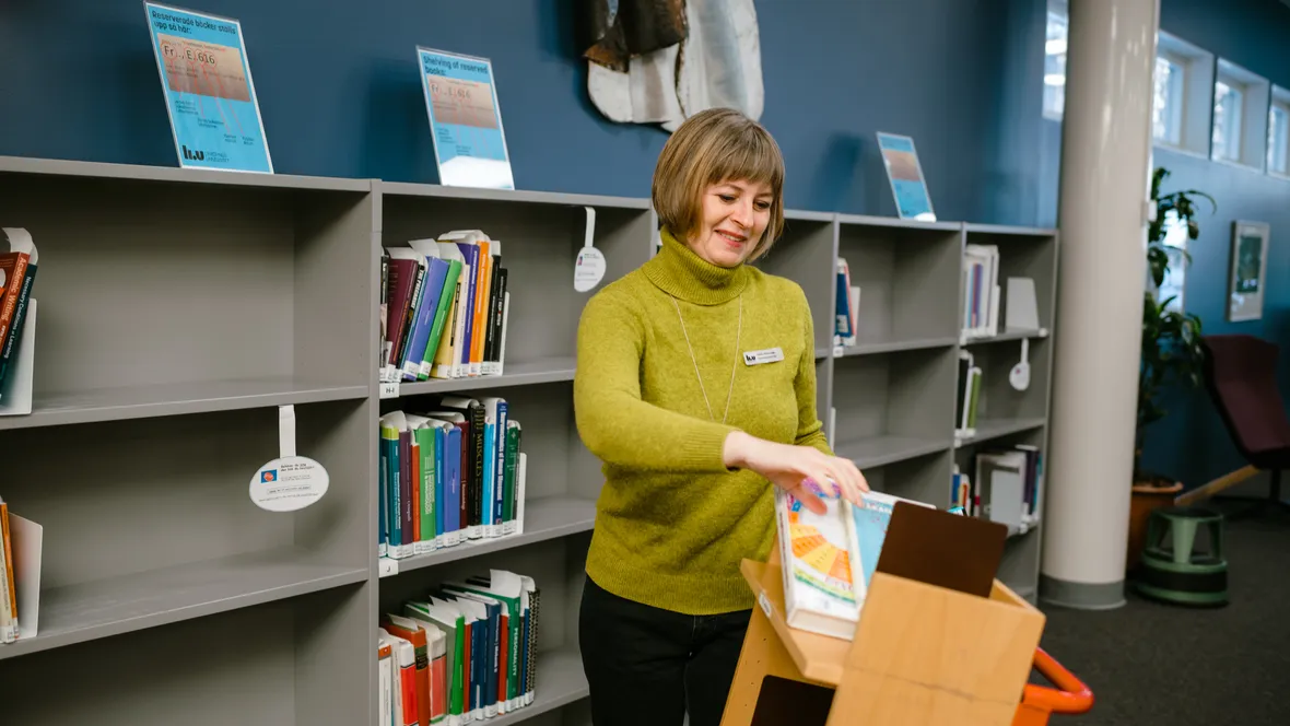 En bibliotekarie vid en bokhylla.