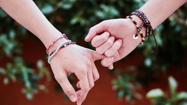Två personers händer som illustrerar samhörighet.