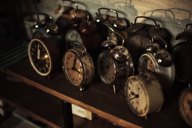 Bild på gamla klockor. De står på ett träbord.