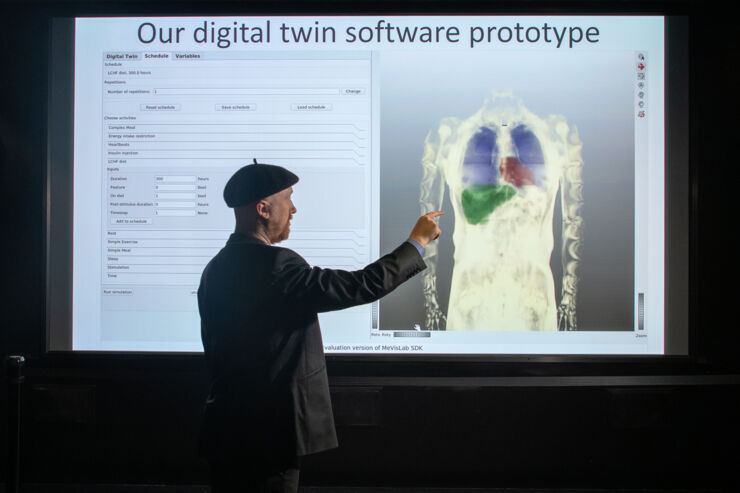 Gunnar Cedersund in front of image illustrating the model of different organs.