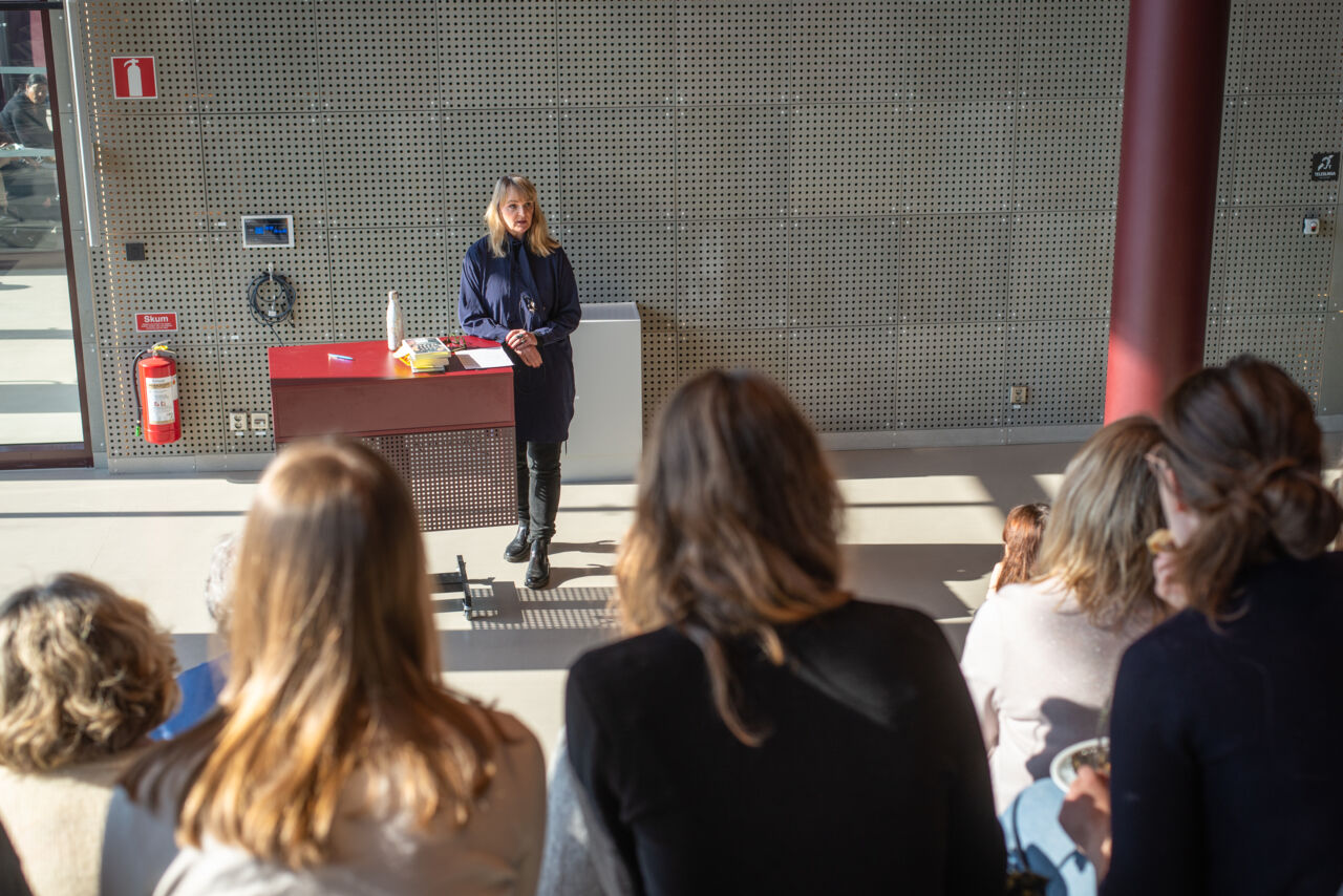 A picture of a woman standing up and holding a lecture in Studenthuset