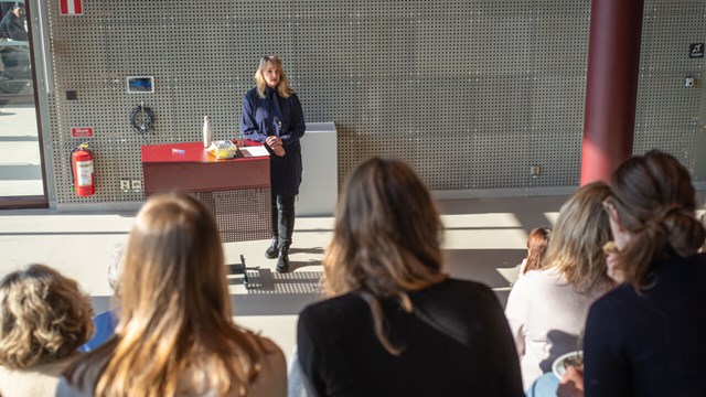 A picture of a woman standing up and holding a lecture in Studenthuset