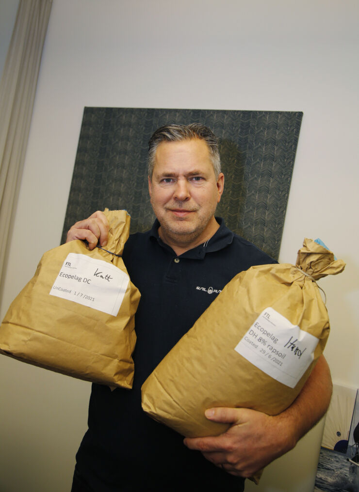 Pär Svärdson holds up two sacks of animal food.