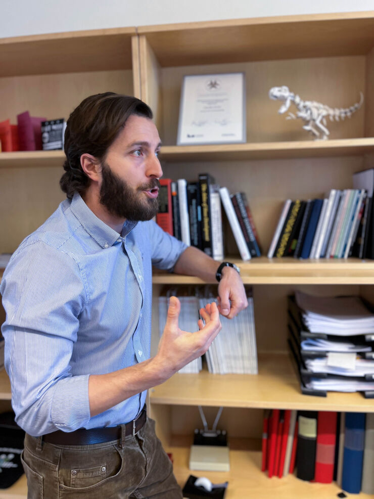 Claudio Cantú talks passionately about his research in front of his bookshelf where we can see the Docent diploma from 2020.