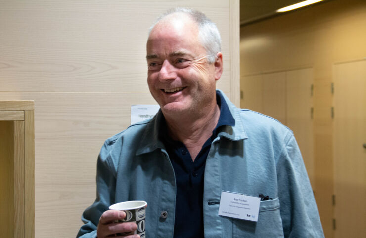 Image of Paul Franken who smiles and enjoys a cup of coffee.