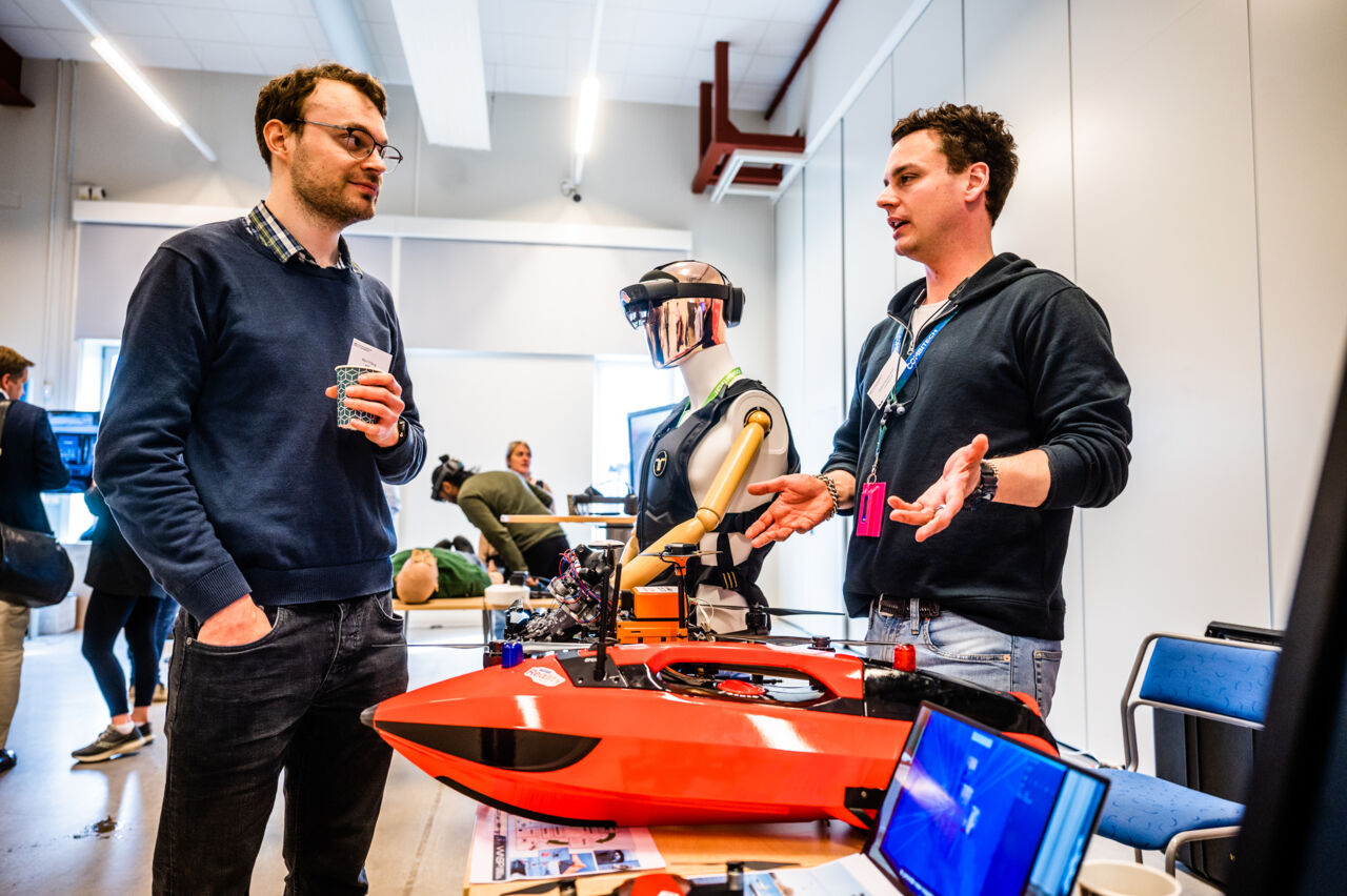 Två personer samtalar vid mässan under konferensen.