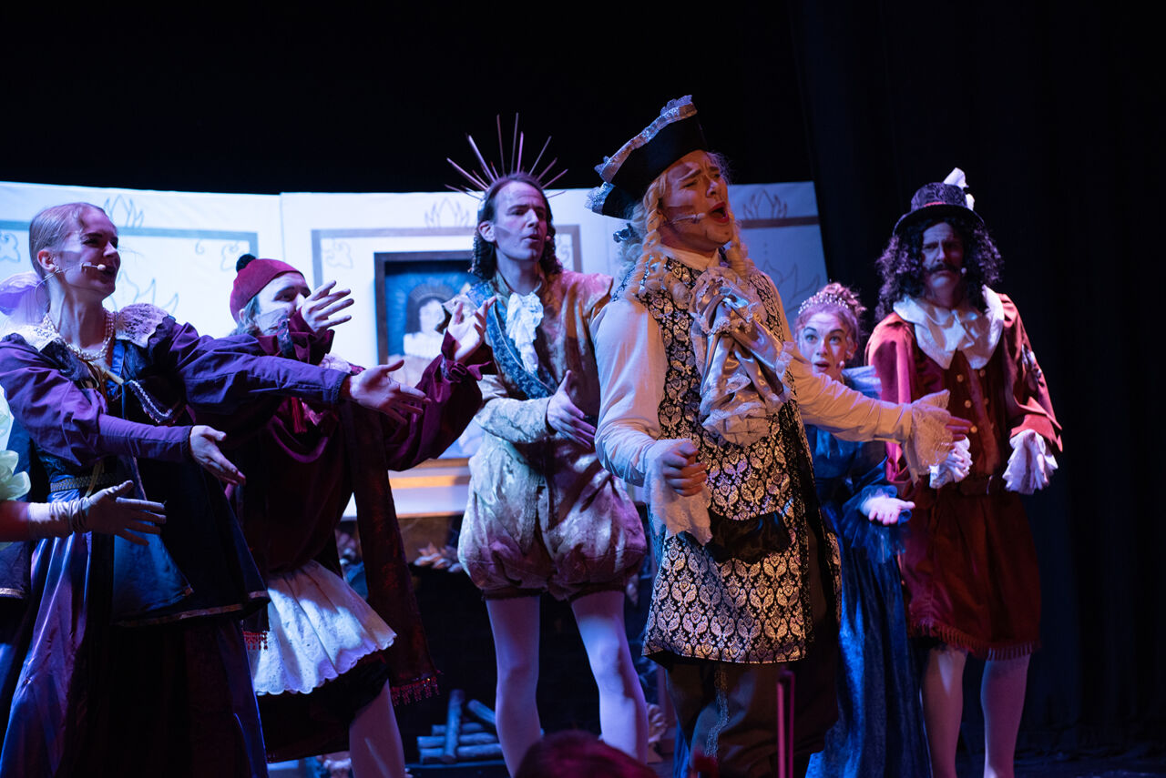 Personer övar på en scen.