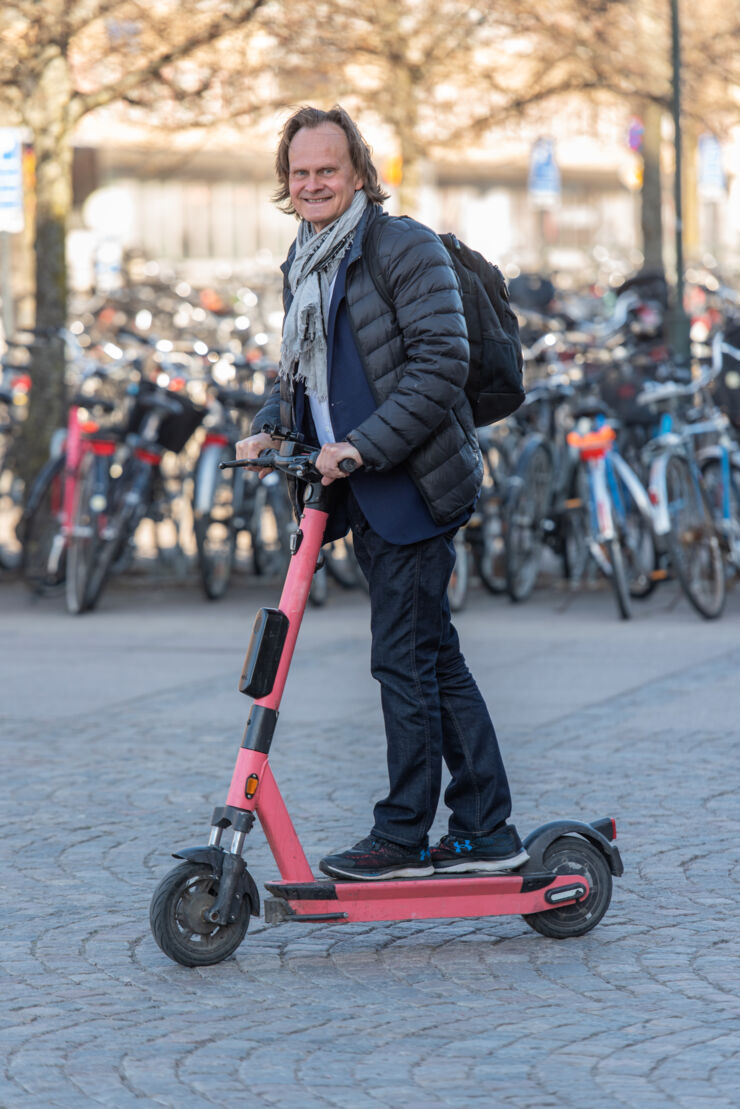 En person står på elsparkcykel.