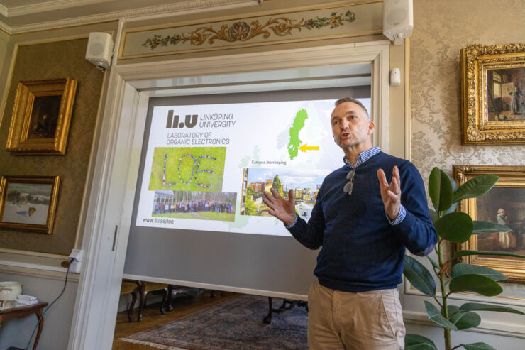 En man står framför en duk där en presentation projiceras