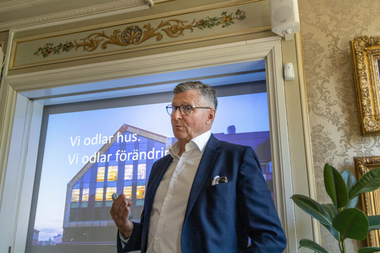 En man står framför en duk där en presentation projiceras