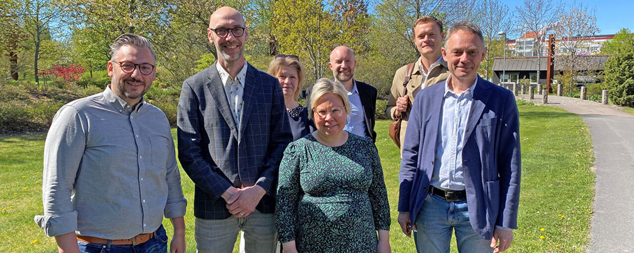 The prefect of the Department of Thematic Studies stands alongside several politicans from Centerpartiet in the sun outside T-building.