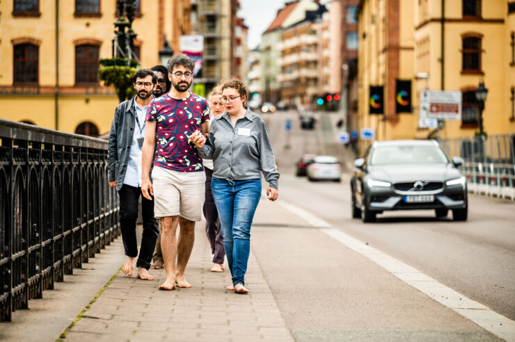 A group of people walk barefoot along Kungsgatan.