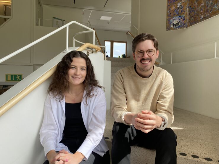 The research assistents are sitting in a staircase.