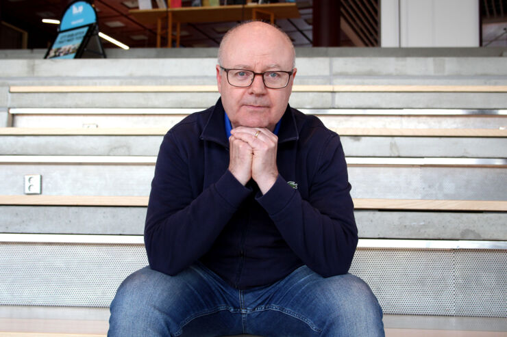 Robert Thornberg is sitting on a large staircase.