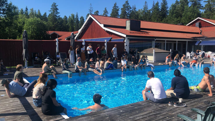 People sitting and discussing by a pool.