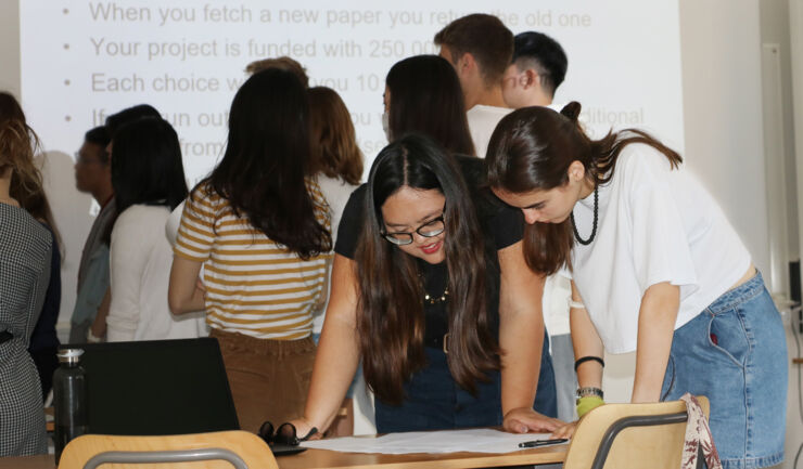 Två internationella studenters som arbetar i föreläsningssal.