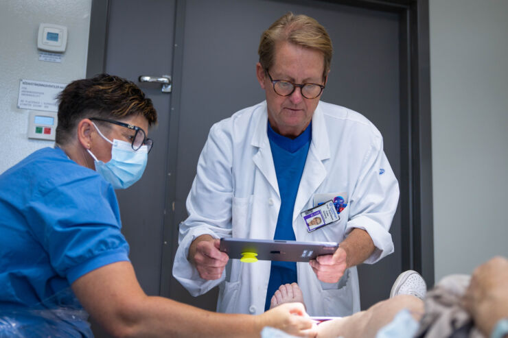 Professor Folke Sjöberg examins a patient's wound