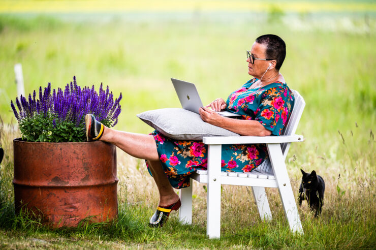A person sits in a chair in a garden.