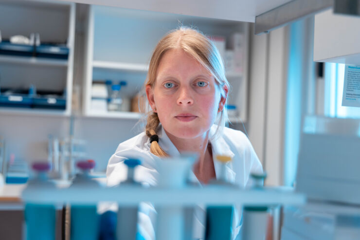 Person in a lab reaching for an instrument.