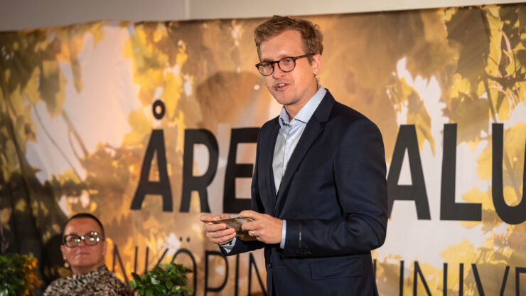 Man (Fredrik Andersson) talar på scen.