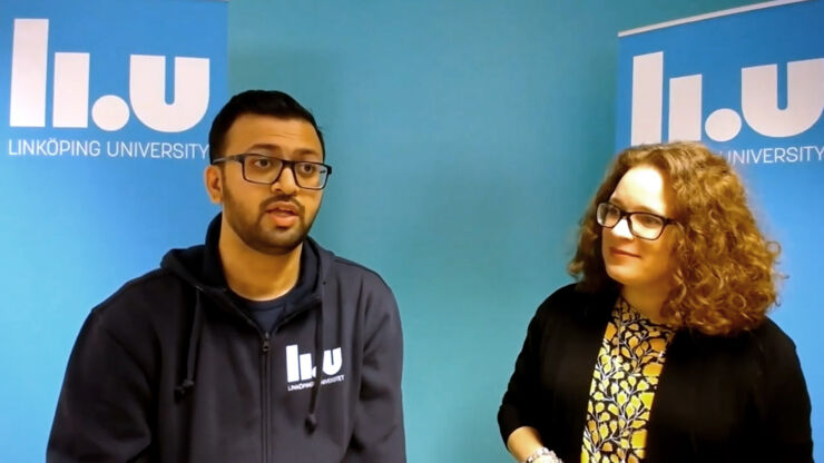 Bespectacled man and woman in front of blue/turqüoise wall