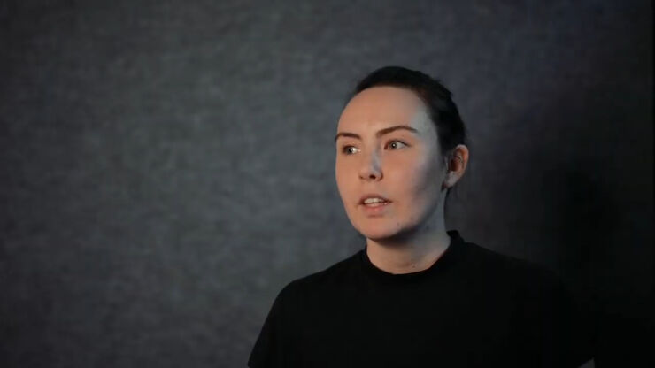 Young woman in front of dark wall