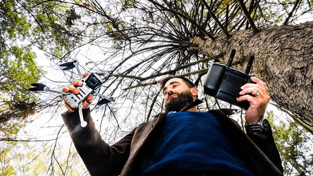 Man with drone in the forest