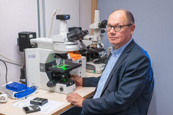 Man sitting by microscope.