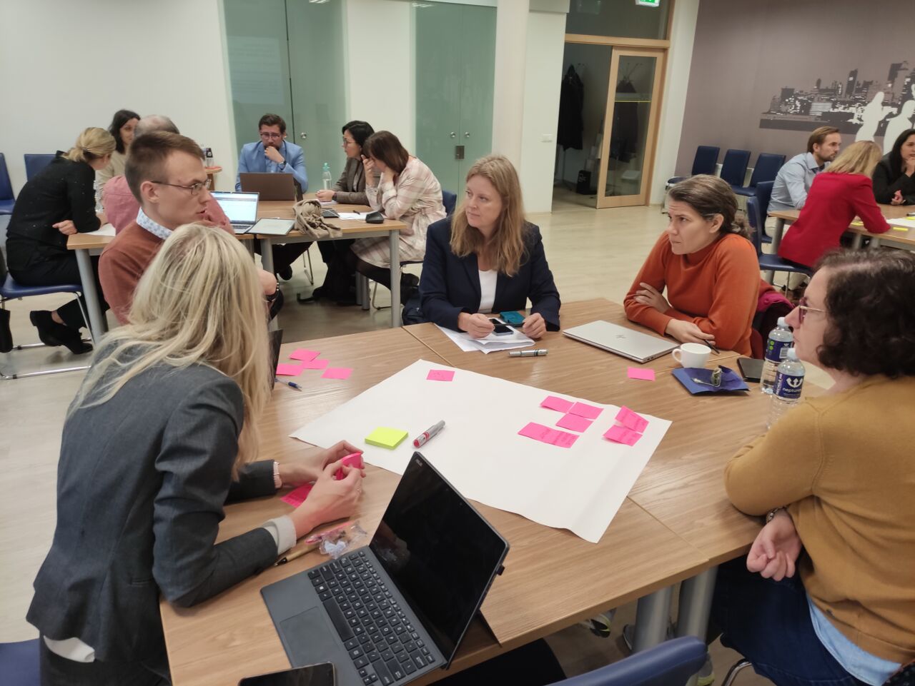 A people sitting around table divided in groups.