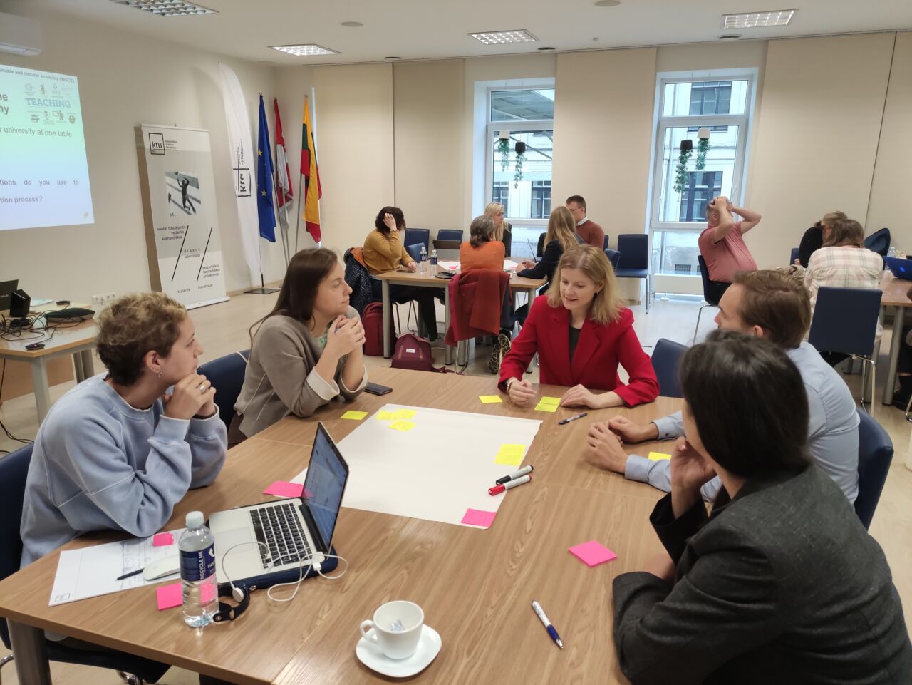 A people sitting around table divided in groups.