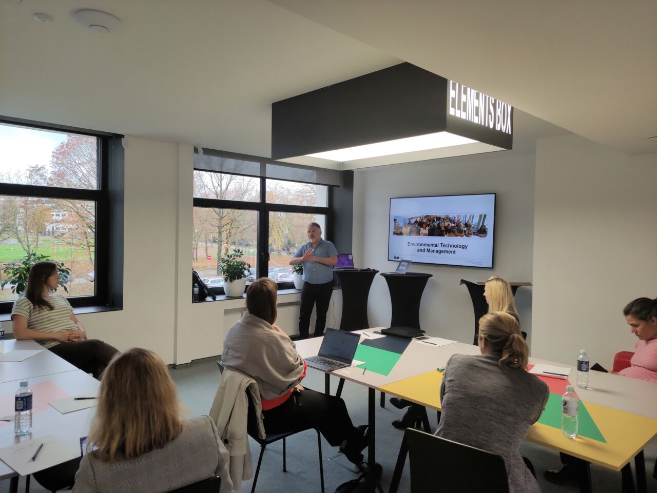 A people sitting around table divided in groups.