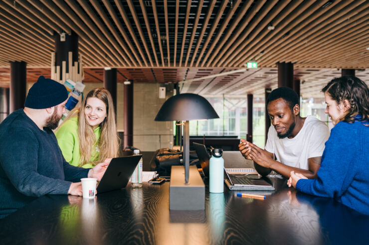 Fyra studenter i studiemiljö