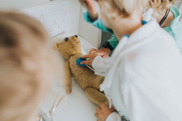 Children playing doctor with teddy bear