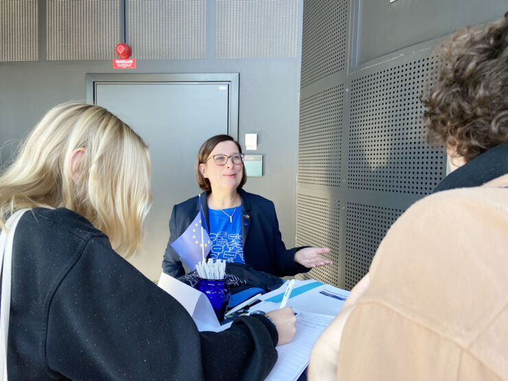 Lena Olofsson-Piras pratar med två studenter.