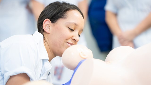 Barnmorskestudent övar handgrepp vid barnafödsel.