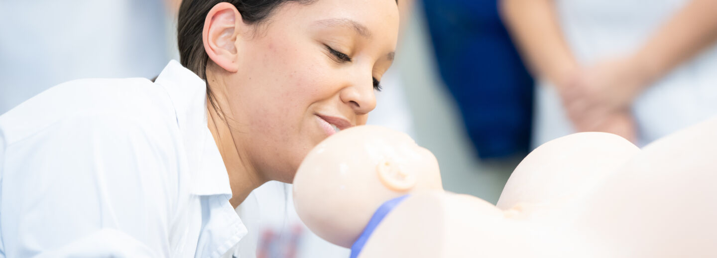 Barnmorskestudent övar handgrepp vid barnafödsel.