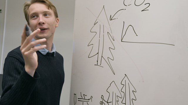 Anton Källström sketching at a whiteboard.
